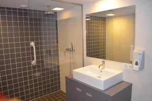 a bathroom with a sink and a shower with a mirror at Rembrandtplein Bed & Breakfast in Amsterdam +17 photos