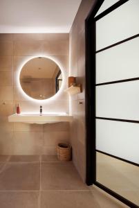 een badkamer met een wastafel en een spiegel bij La perle rouge A Panazol in Panazol