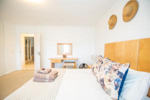 a bedroom with a white bed with a pillow at No. 30 in Plett in Plettenberg Bay +39 photos