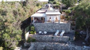 una vista aérea de una casa con una pared de piedra en La Torre di Merlino, en Patù
