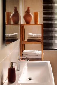 uma casa de banho com lavatório e prateleiras com toalhas em Merveilleuses chambres d'hôtes à Panazol em Panazol