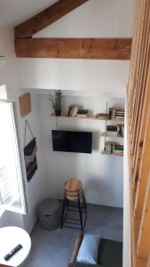 a room with a chair and a tv on a wall at le Chartreuse / Rent4night Grenoble in Grenoble