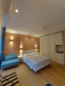 una camera con letto e sedia blu di Hotel Borgovico a Como