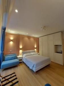 a bedroom with a bed and a blue chair at Hotel Borgovico in Como