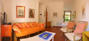 una sala de estar con un sofá y sillas en Villaggio la Serra - Appartamenti con giardino, en Marina di Campo