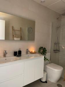 a bathroom with a sink and a toilet and a mirror at Apartamento de lujo con piscina en Tarifa in Tarifa