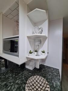 a kitchen with white cabinets and a microwave at Cozy Cabin in Midrand