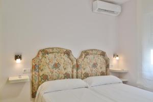 1 dormitorio con 1 cama con cabecero de flores en SunShine Buen Pastor, en Córdoba