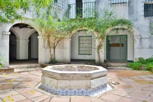 a building with a fountain in the middle of a courtyard at SunShine Buen Pastor in Córdoba
