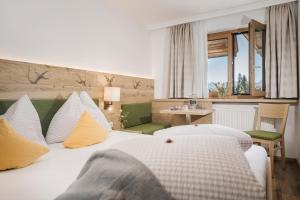 um quarto com uma grande cama branca com almofadas amarelas em Café Pension Koller em Brixen im Thale