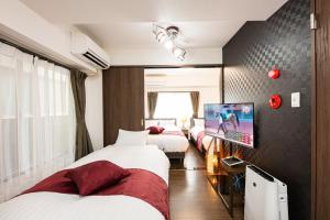 Habitación de hotel con 3 camas y TV de pantalla plana. en Vacation Rental NISHIDA - Vacation STAY 61670v en Kagoshima