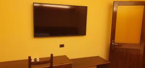 a classroom with a table and a television on a yellow wall at Il Carrettino Country Hotel in Tortona