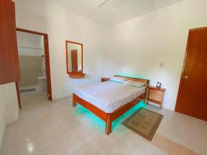 um quarto com uma cama e um espelho em Coconut Palm House - El Cuyo em El Cuyo
