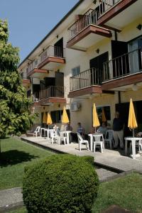 a group of people sitting in chairs in front of a building at Arcada Hotel in Tocha