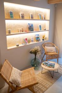 a room with two chairs and a table and shelves with books at Marosi Boutique Hotel in Ciutadella