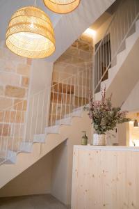 a staircase in a house with two lights and a vase of flowers at Marosi Boutique Hotel in Ciutadella