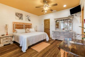 a bedroom with a bed and a sink and a ceiling fan at de la Bleau B&B in Mandeville