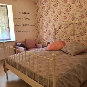 - une chambre avec un lit orné de fleurs sur le mur dans l'établissement Appartement au cœur du Haut-Jura, à Villard-Saint-Sauveur