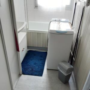 baño con bañera, aseo y alfombra azul en Studio avec terrasse amenagee et wifi a Allevard, en Allevard