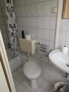 a white bathroom with a toilet and a sink at Ferienpark Stausee Quitzdorf in Kollm