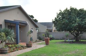 a yard with a house and a tree at 14 Cluster House & Studio in George