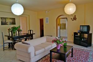 a living room with a white couch and a table at Ktima Dafnes in Nafplio