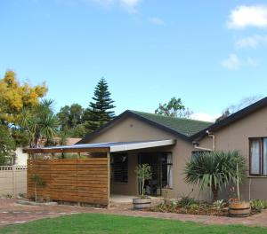 a house with a wooden fence in a yard at 14 Cluster Cottages in George