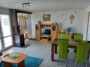 ein Wohnzimmer mit einem Tisch und grünen Stühlen in der Unterkunft SRB Sadovo-Resort-Bulgaria in Sadovo