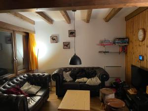 una sala de estar con 2 sofás de cuero y una mesa. en Chalet Sonnenröschen en Blatten bei Naters