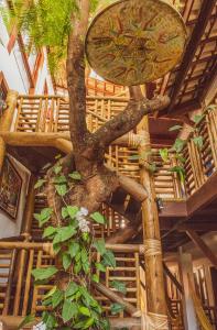 a tree in the middle of a room with a building at Pousada João Sol in Praia do Forte