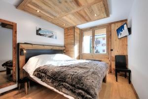 una camera con un letto e una sedia di Appartement familial au pied de la télécabine 4* a Saint-Gervais-les-Bains