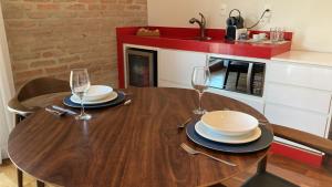 a wooden table with two glasses and plates on it at Austin Suites in Campos do Jordão