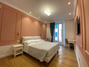 a bedroom with a bed and a desk and a television at Hotel Borgovico in Como