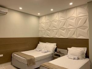 1 dormitorio con 2 camas y toallas. en Hotel Lider, en Paranaguá