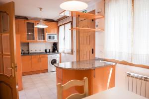 a kitchen with orange cabinets and a counter top at Apartamentos Torre Cristina in Noja