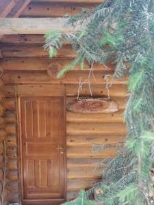 Cabaña de madera con puerta y árbol en Brvnare filip, en Nova Varoš