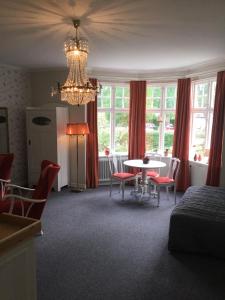 a bedroom with a table and chairs and a chandelier at Villa Blenda in Borgholm