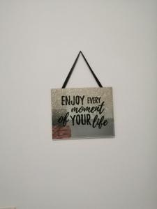 a sign that reads enjoy every moment of your life at Sun & Love Apartment in Koper