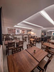 伊塔博拉伊Kaluff Hotel的配有木桌椅的餐厅