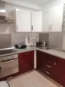 a kitchen with white cabinets and a sink at Sun & Love Apartment in Koper