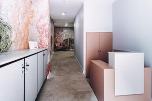 uma cozinha com armários brancos e um corredor com um sofá em GBH Hotel-Apartamentos Estrella de Mar em Benidorm