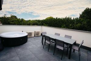 eine Terrasse mit einem Tisch, Stühlen und einer Badewanne in der Unterkunft Résidence Palace Expo in Brüssel
