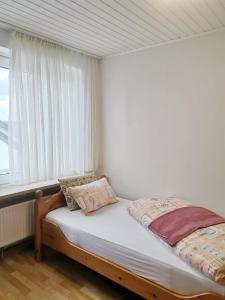 a small bed in a room with a window at FeWo Royal & Goodness Home in Mühlhausen