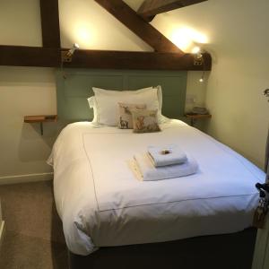 a bedroom with a large bed with white sheets and pillows at The Barn in Monk Fryston