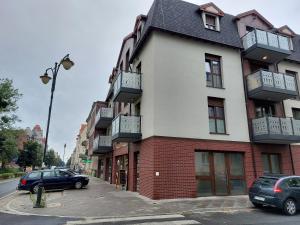 un bâtiment avec des voitures garées dans un parking dans l'établissement Apartament LindEGO, à Toruń