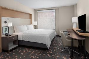 a hotel room with a bed and a desk and a computer at Holiday Inn Hasbrouck Heights-Meadowlands by IHG in Hasbrouck Heights