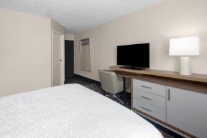 a bedroom with a bed and a desk with a television at Holiday Inn Hasbrouck Heights-Meadowlands by IHG in Hasbrouck Heights