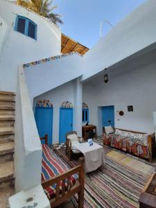 a living room with white walls and blue doors at Aswan Nubian House in Aswan