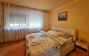 1 dormitorio con 1 cama y una ventana con cortinas en Apartment Garden, en Slunj