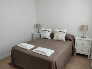 um quarto com uma cama com duas mesas e dois candeeiros em b Apartamentos Diego em O Grove